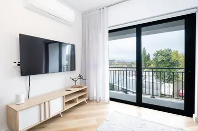 a living room with a television and a balcony at Paarl - Lux Modern 2 Bedroom Apartment with Parking in Paarl