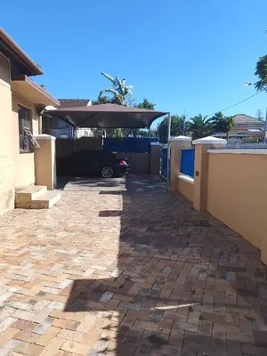 a driveway of a house with a car parked under an umbrella at Duminy Lodge Monthly Rentals in Bellville