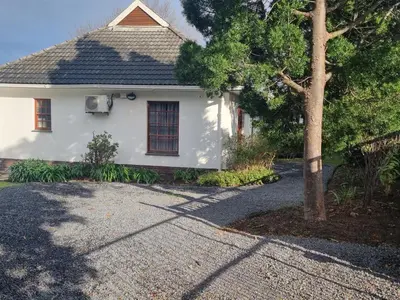 a white house with a tree in front of it at Somerset West Stay 2 in Somerset West