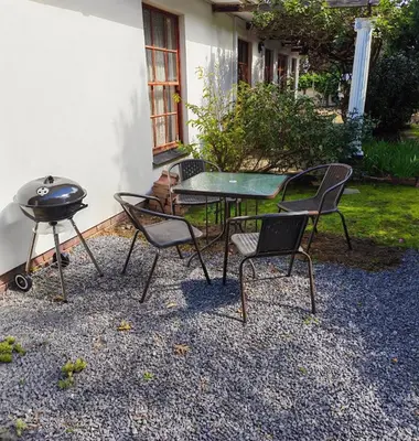 a table and chairs with a grill and a barbecue at Somerset West Stay 2 in Somerset West