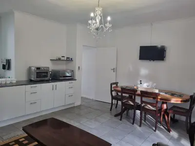 a kitchen with a table and a dining room at Somerset West Stay 2 in Somerset West