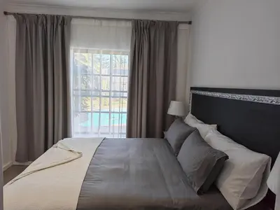 a bedroom with a large bed with a window at Somerset West Stay 2 in Somerset West