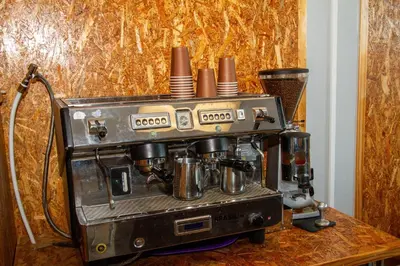 an old espresso machine sitting on a wooden table at Lodge Luxe, Cozy Bedrooms, Free WiFi, Robust Security in Cape Town