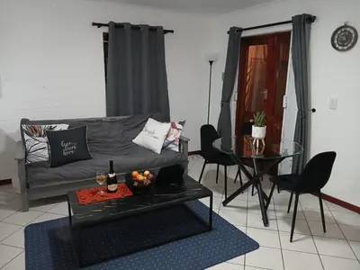 a living room with a couch and a glass table at Fisherman's Haven in Bloubergstrand