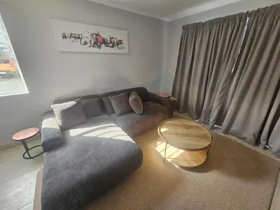 a living room with a couch and a table at 180 Mont Blanc in Gordonʼs Bay