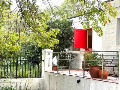 a house with a red door on a balcony at 3 Uitsig Street, Rozendal, Stellenbosch in Stellenbosch