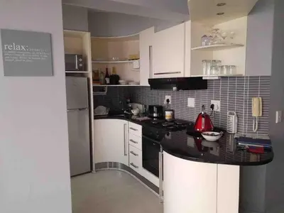 a kitchen with white cabinets and a black counter top at 401 Pip's Place in Strand
