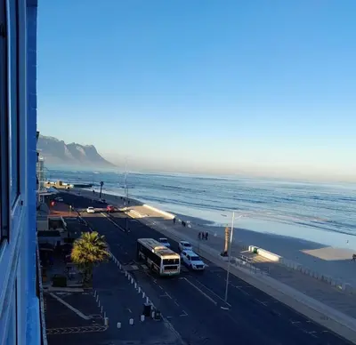 a bus driving down a road next to the beach at 401 Pip's Place in Strand