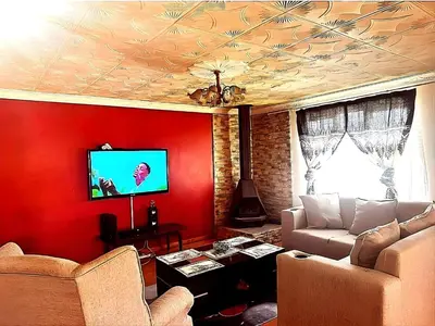 a living room with a couch and a red wall at Peace Accommodation B&B in Silver Sands