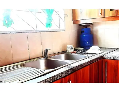 a kitchen with a sink and a counter top at Peace Accommodation B&B in Silver Sands