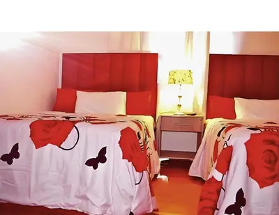 a bedroom with two beds with red and white sheets at Peace Accommodation B&B in Silver Sands
