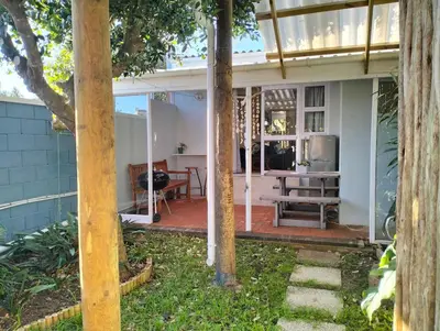 a screened in porch of a house with a bench at Garden es Cape in Pringle Bay