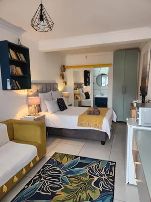 a hotel room with two beds and a kitchen at G's Apartments Cape Town in Windsor Park