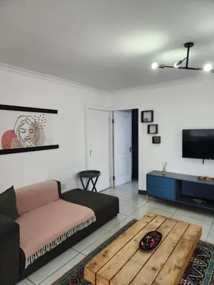 a living room with a couch and a table at G's Apartments Cape Town in Windsor Park