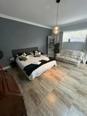 a bedroom with a bed and a couch at Spacious Bachelor Die Boord in Stellenbosch