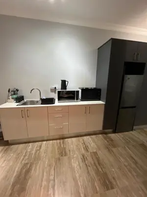 an empty kitchen with a sink and a refrigerator at Spacious Bachelor Die Boord in Stellenbosch