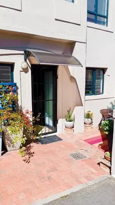 an entrance to a building with potted plants at Entire 2 Level Townhouse in Backenfell Cape Town in Brackenfell
