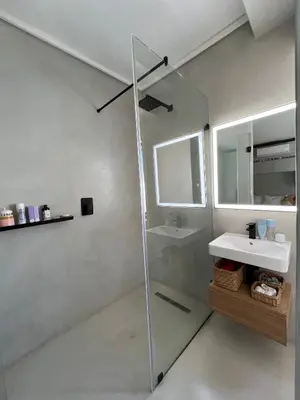 a bathroom with a glass shower and a sink at Villa Victoria in Paarl