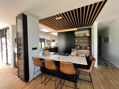 a kitchen with a counter with chairs around it at Villa Victoria in Paarl