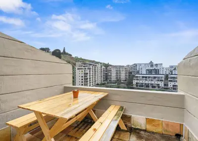 a wooden table on a balcony with a view of a city at The Tygervalley Escape in Cape Town
