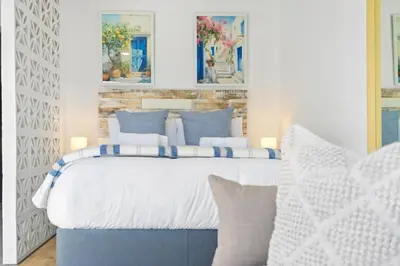 a bedroom with a bed with blue and white pillows at Studio on North in Cape Town