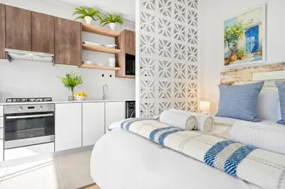 two beds in a kitchen with white cabinets at Studio on North in Cape Town