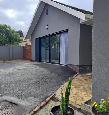 a house with a large glass door on the side of it at Garden studio flat in Panorama