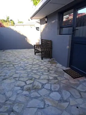 a wooden bench sitting outside of a house at Garden studio flat in Panorama