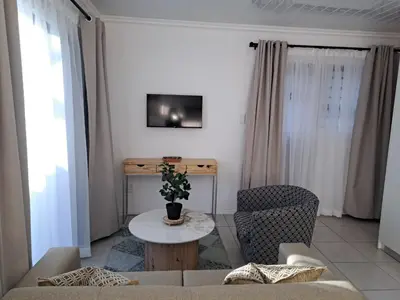 a living room with a couch and a table at Garden studio flat in Panorama