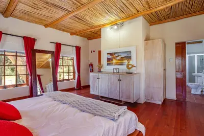 a bedroom with a large bed and a bathroom at Calais Wine Estate in Paarl