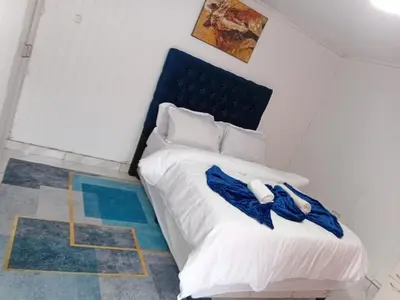 a bedroom with a bed with two blue robes on it at PEACEFUL SLEEP lodge 1 in Goodwood