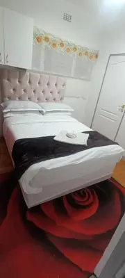 a bedroom with a large white bed with a red carpet at PEACEFUL SLEEP lodge 1 in Goodwood