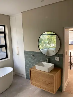 a bathroom with a sink and a mirror at Luxury Home in Security Golf Estate with Ocean Terrace in Cape Town