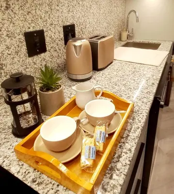 a kitchen counter with two plates and cups on a tray at Platform 133 2 Tabak in Paarl
