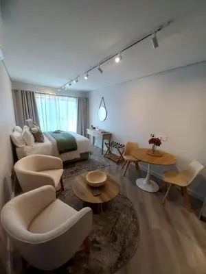 a hotel room with a bed and tables and chairs at Platform 133 2 Tabak in Paarl