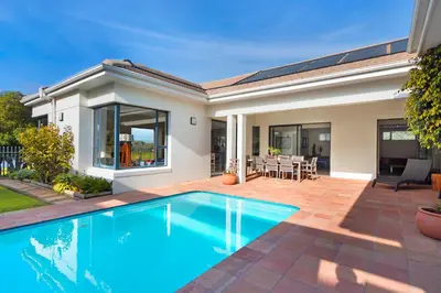 a swimming pool in front of a house at Villa on 15th Waters Edge, Cape Town in Cape Town