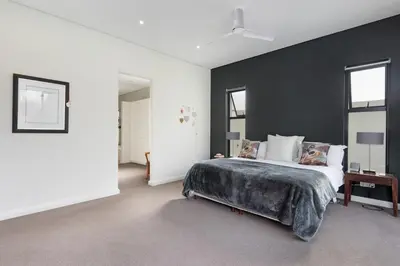 a bedroom with a large bed with a black wall at Villa on 15th Waters Edge, Cape Town in Cape Town