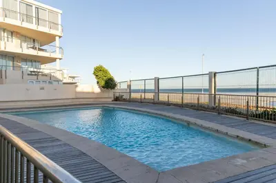 a swimming pool on the balcony of a building at 2 Bedroom Seaview, Holiday Apartment, Lagoon Beach in Cape Town