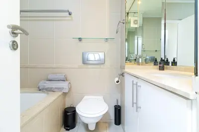 a bathroom with a toilet and a tub and a sink at 2 Bedroom Seaview, Holiday Apartment, Lagoon Beach in Cape Town