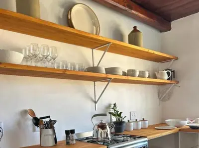 a kitchen with wooden shelves and a stove top oven at Ceres Hideaways