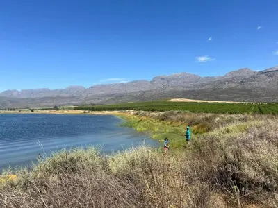 two people standing next to a body of water at Ceres Hideaways
