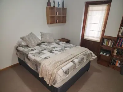 a bedroom with a bed and a book shelf at Fairway Corner in Villiersdorp