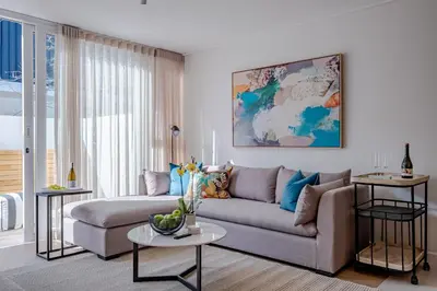 a living room with a couch and a table at Chic Coastal Hideaway in Hermanus