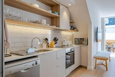 a kitchen with white cabinets and a sink at Chic Coastal Hideaway in Hermanus