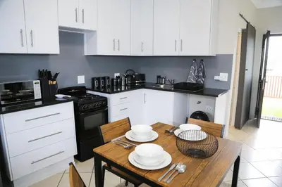 a kitchen with a wooden table and white cabinets at Schutterend in Nieuwe Drift