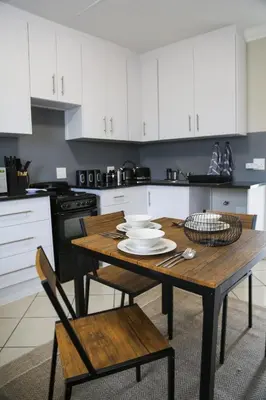a kitchen with a wooden table and white cabinets at Schutterend in Nieuwe Drift