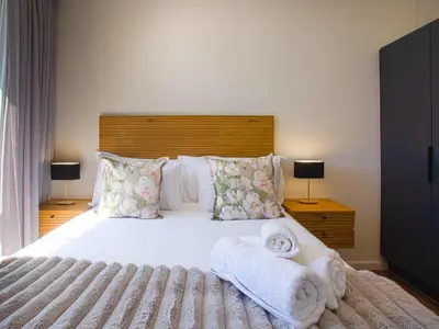 a bedroom with a large bed with towels on it at On Park Century City in Cape Town