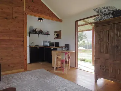 a room with a table and a kitchen with a window at Hoopoe Cottage Horns op de Hoek in Hartebeest Rivier