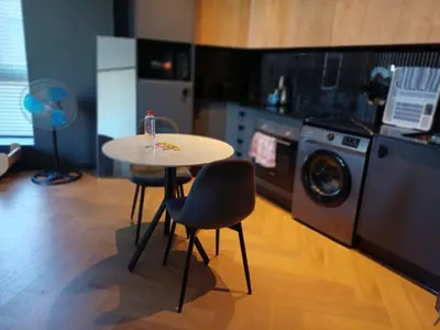 a kitchen with a table and a washing machine at 1bedroom Luxe Nine Palms near Canal Walk in Cape Town