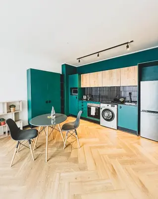a kitchen with green walls and a table and chairs at 1bedroom Luxe Nine Palms near Canal Walk in Cape Town